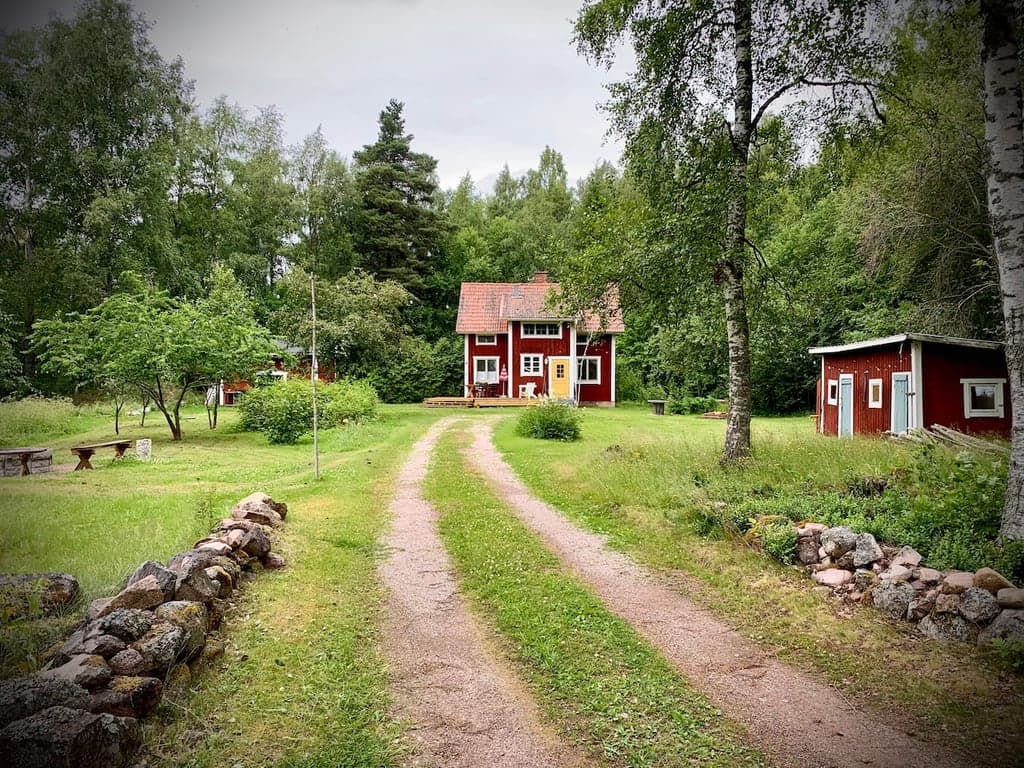 Autentisk röd stuga omgiven av skog och natur på Sollerön. Privat tomt med grusväg, trädgård och lugn landsbygdsmiljö.